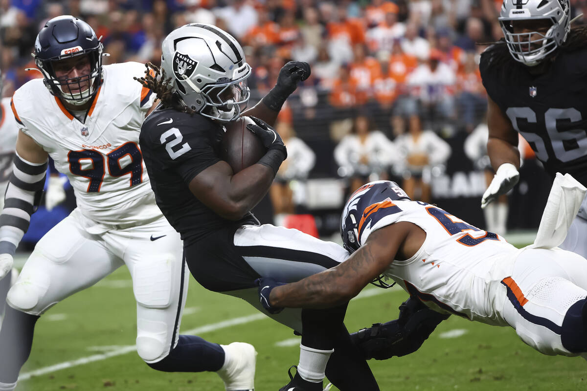 Raiders running back Ashton Jeanty (2) gets tackled by Denver Broncos linebacker Dre Greenlaw ( ...