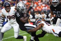Raiders running back Ashton Jeanty (2) gets tackled by Denver Broncos linebacker Dre Greenlaw ( ...