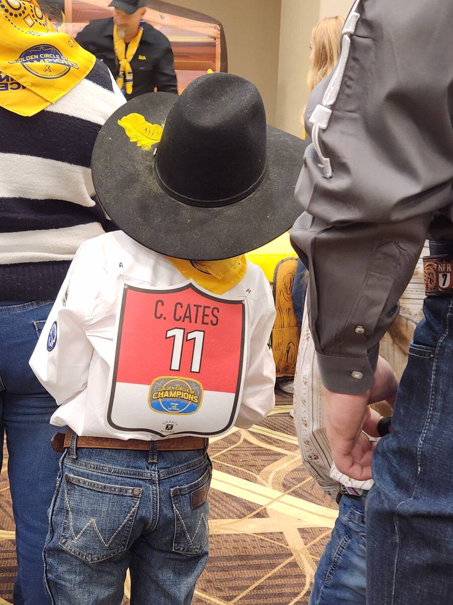 World champion team roper Junior Nogueira shares his hat with a child during Saturday's Golden ...