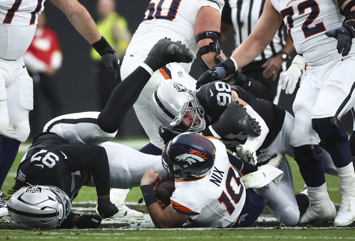 Denver Broncos quarterback Bo Nix (10) gets sacked by Raiders defensive end Maxx Crosby (98) an ...