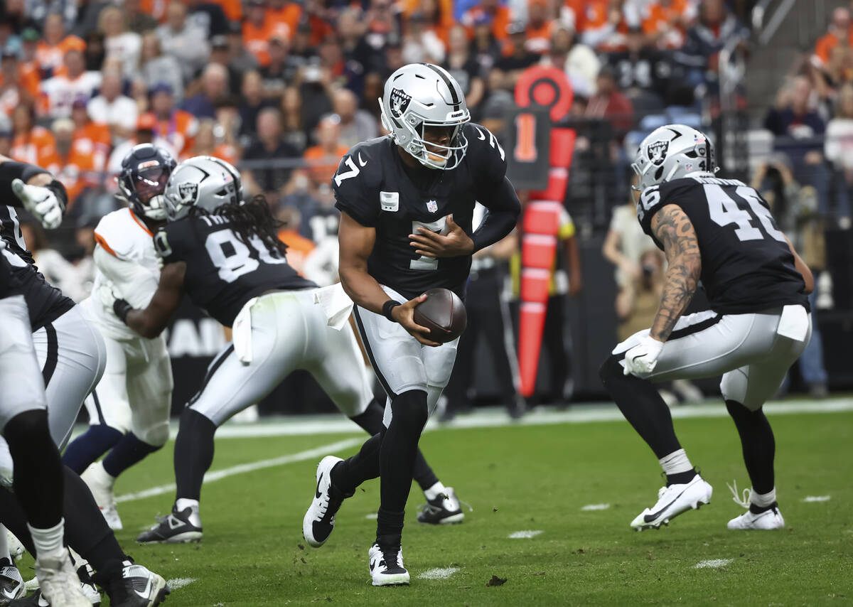 Raiders quarterback Geno Smith (7) looks to hand off the ball during the first half of an NFL g ...