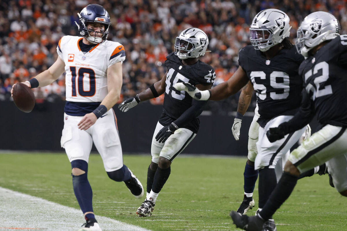 Denver Broncos quarterback Bo Nix (10) is chased by a trio of Raiders defenders during the seco ...