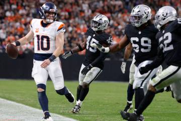 Denver Broncos quarterback Bo Nix (10) is chased by a trio of Raiders defenders during the seco ...