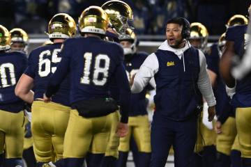 Notre Dame head coach Marcus Freeman, right, celebrates with kicker Erik Schmidt (18) on the si ...