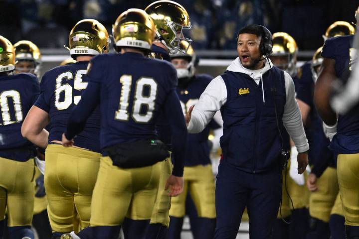 Notre Dame head coach Marcus Freeman, right, celebrates with kicker Erik Schmidt (18) on the si ...