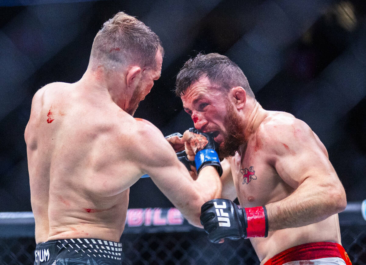 Petr Yan connects with a punch to the face of Merab Dvalishvili during their bantamweight title ...