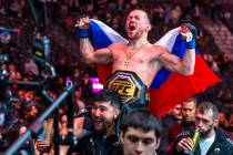 Petr Yan is carried from the octagon with his new belt after defeating Merab Dvalishvili during ...