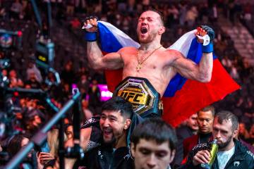 Petr Yan is carried from the octagon with his new belt after defeating Merab Dvalishvili during ...