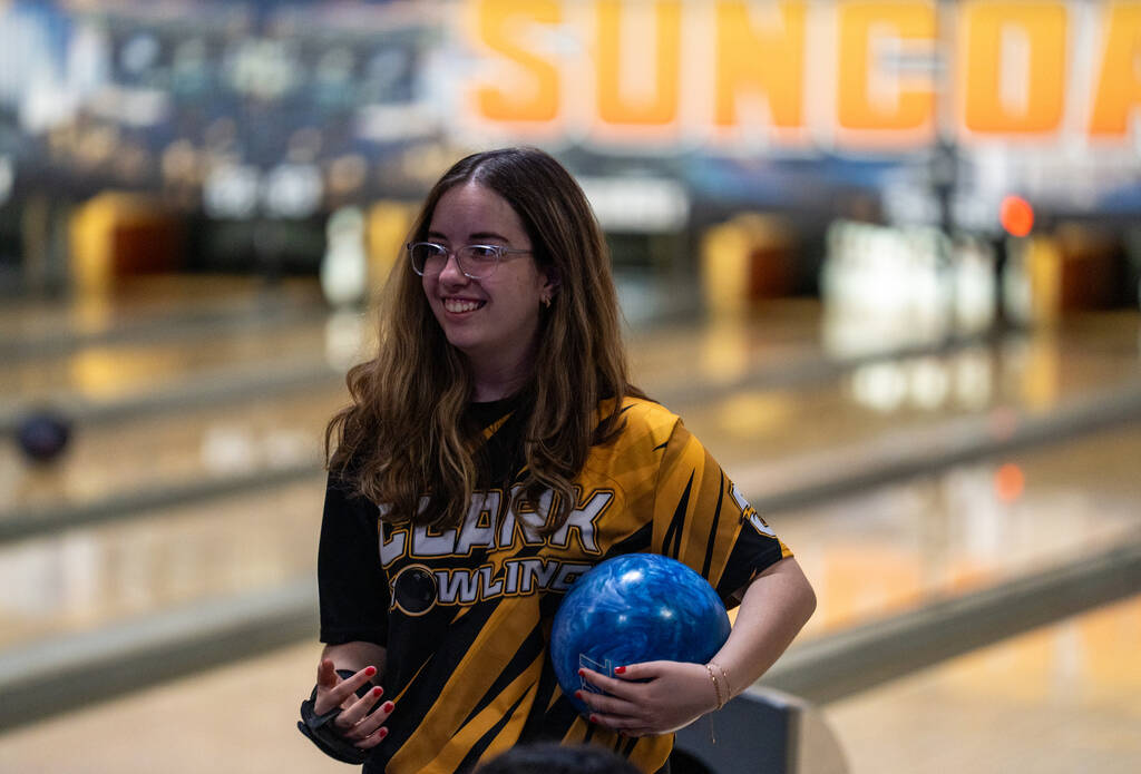 Clark’s Sadie Foster laughs with her teammates before her turn during a 5A bowling match ...