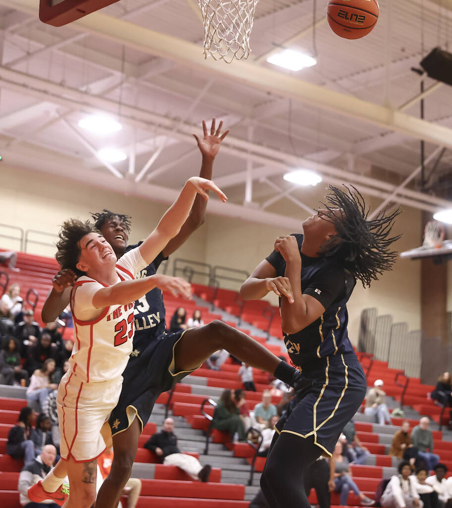 Arbor View guard Thaddeus Thatcher (23) gets fouled by Spring Valley forward Nasir Greene (23) ...