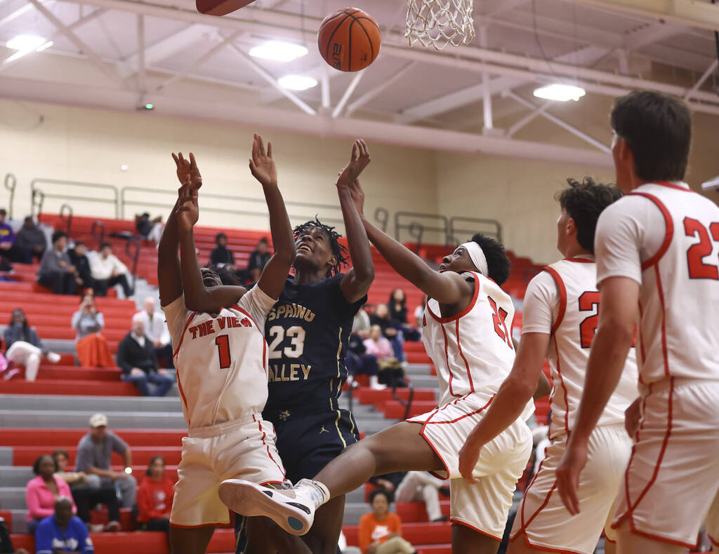 Spring Valley forward Nasir Greene (23) vies for a rebound between Arbor View guard Elijah Pier ...
