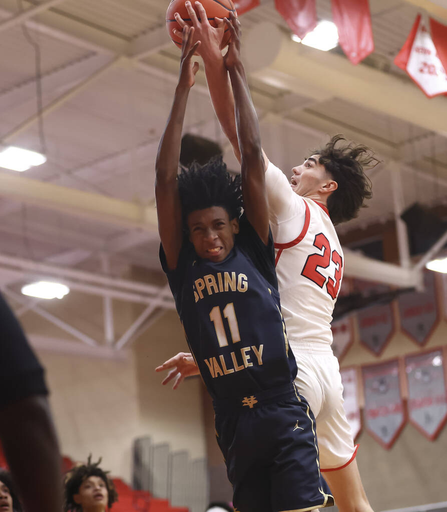Arbor View guard Thaddeus Thatcher (23) gets fouled by Spring Valley guard Jonovan Jeffery (11) ...