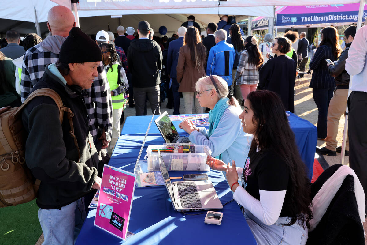 Kimberly Padilla-Estrada, right, helps a library member during the grand opening of the new Wes ...