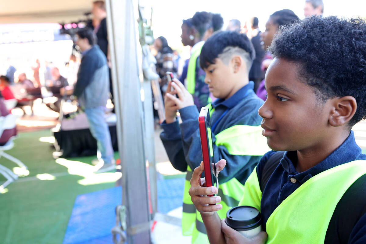 Randy Miller, 11, of West Preparatory Academy, films a speaker during the grand opening of the ...