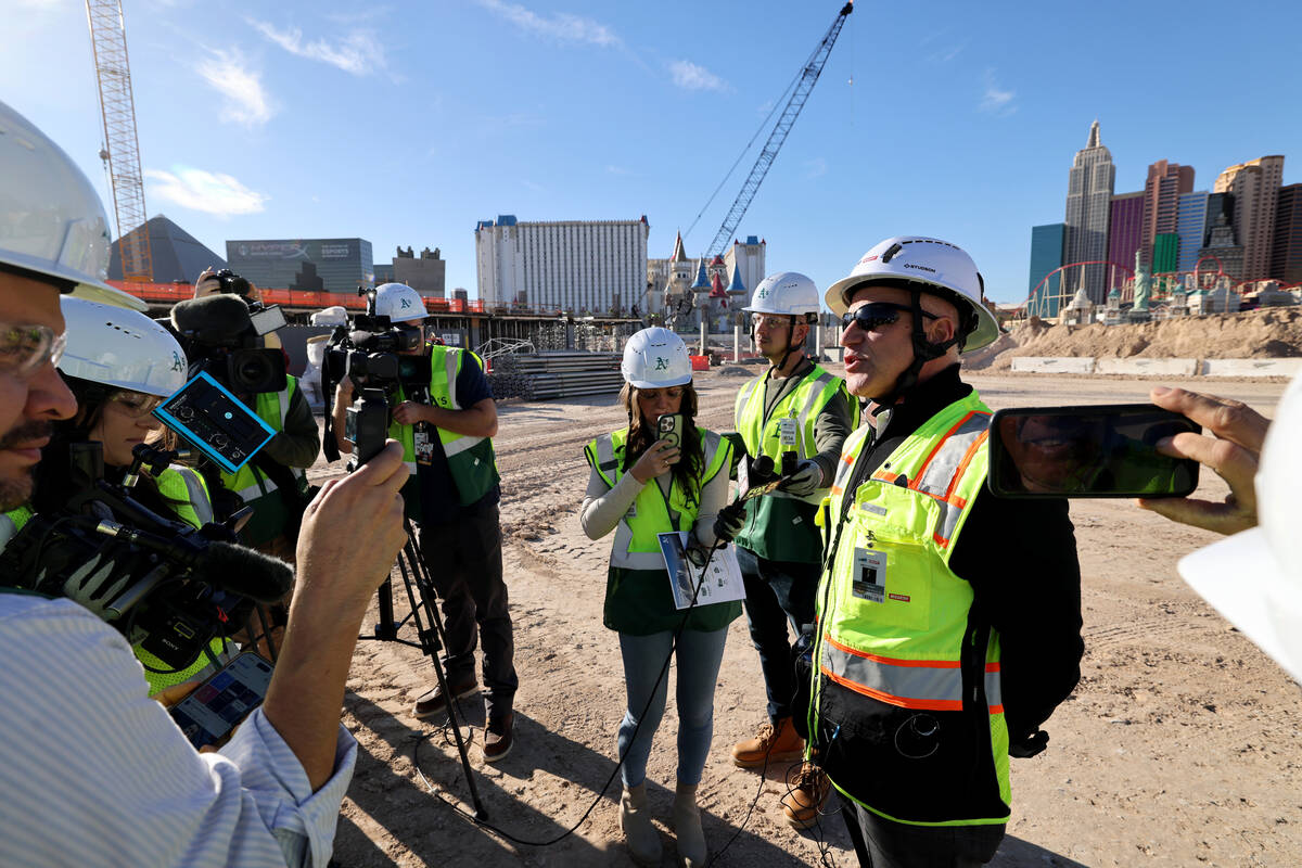 Athletics president Marc Badain, right, talks to members of the news media during construction ...