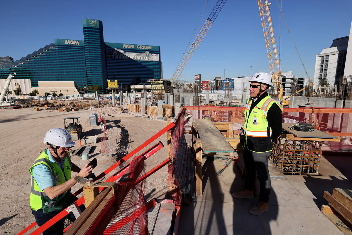 Athletics president Marc Badain, right, talks to members of the news media during construction ...