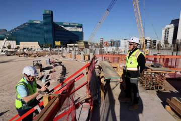 Athletics president Marc Badain, right, talks to members of the news media during construction ...