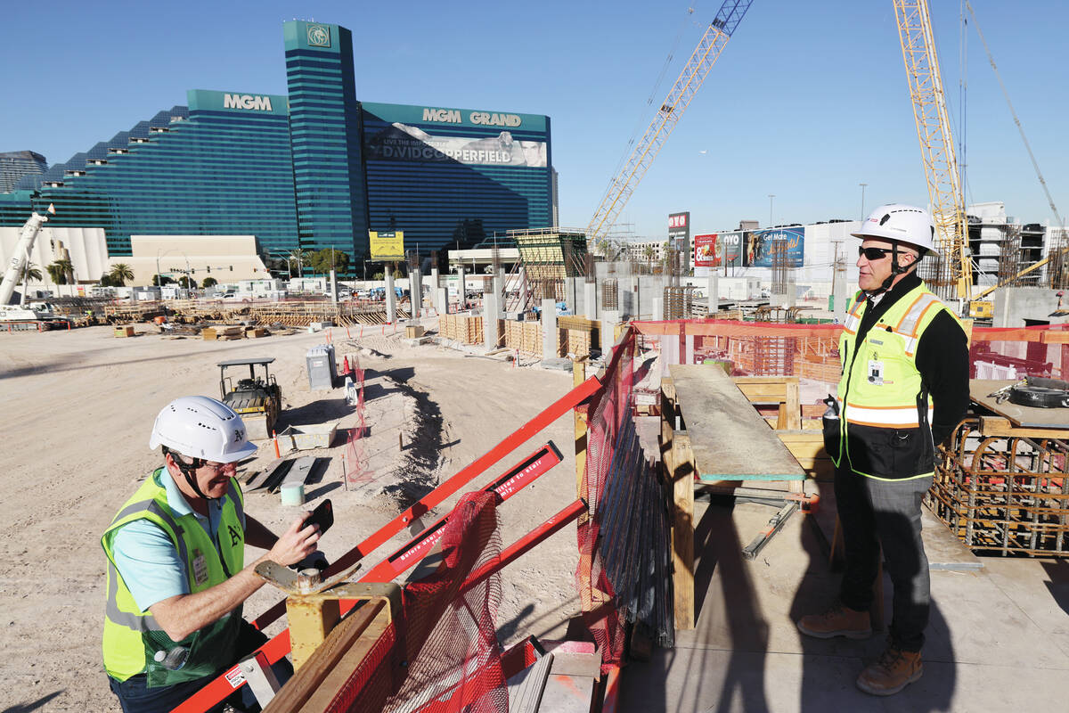 Athletics president Marc Badain, right, talks to members of the news media during construction ...