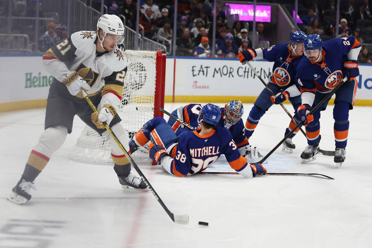 Vegas Golden Knights' Brett Howden (21) handles the puck as New York Islanders' Travi ...