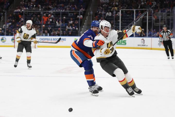 New York Islanders' Scott Mayfield (24) and Vegas Golden Knights' Pavel Dorofeyev collide while ...