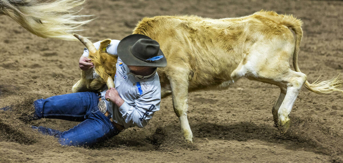Jesse Brown takes down his steer in Steer Wresting during Day 6 of National Finals Rodeo at the ...