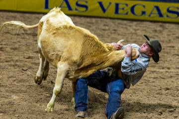 Jesse Brown takes down his steer in Steer Wresting during Day 6 of National Finals Rodeo at the ...