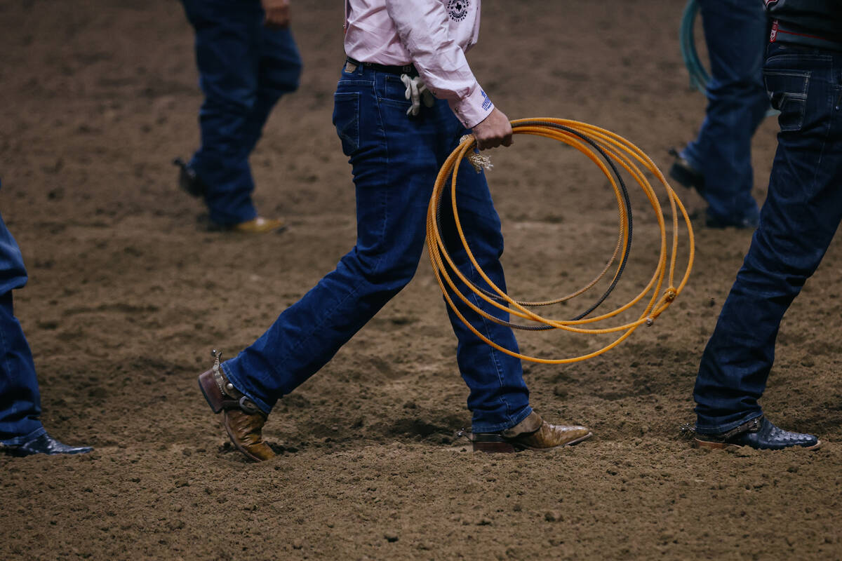 Rodeo competitors walk out to be introduced before the seventh go-round of the National Finals ...