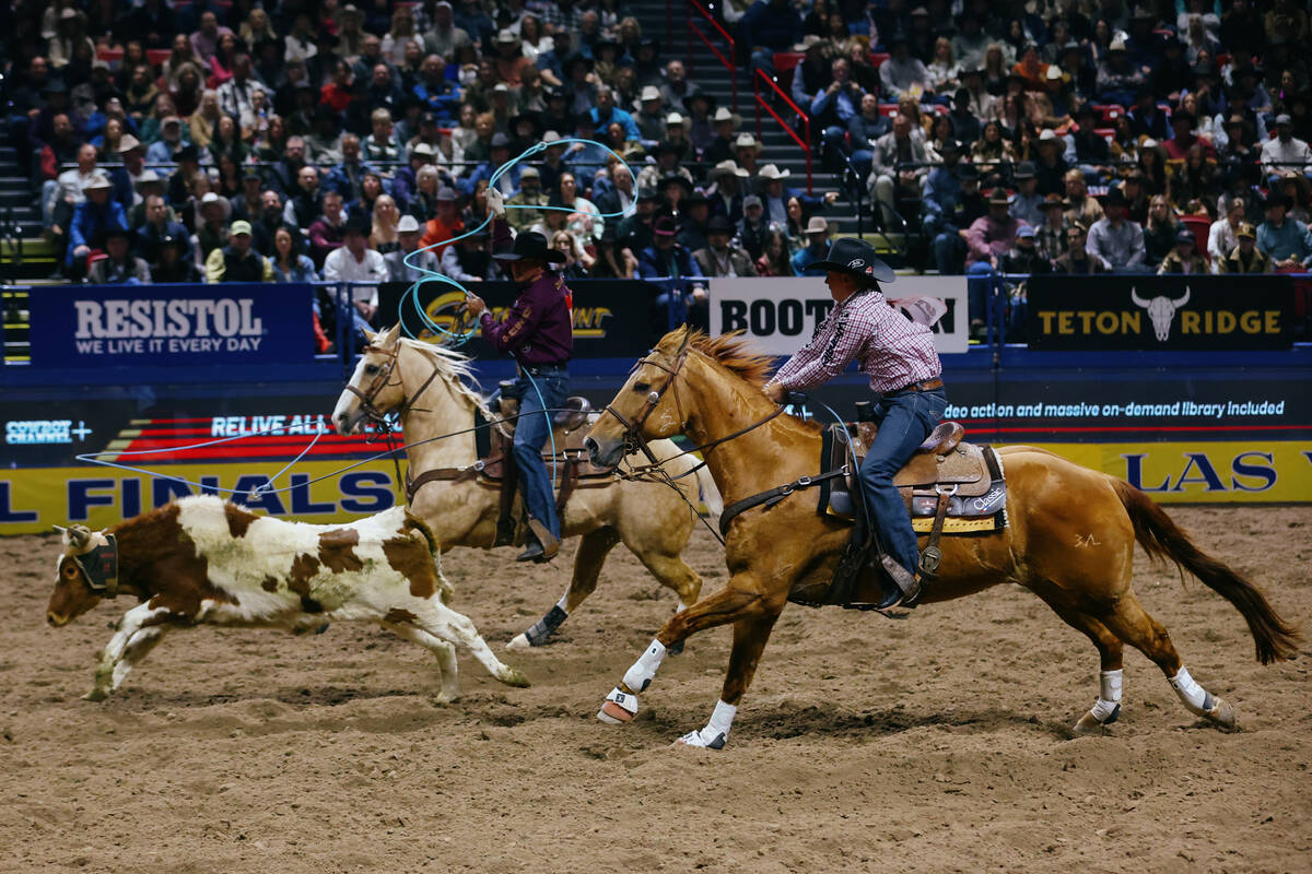 Clint Summers and Jade Corkill compete in the team roping event during the seventh go-round of ...