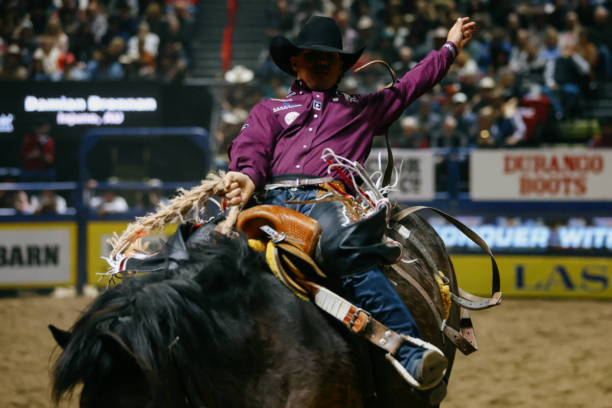 Damian Brennan rides Apollo in the saddle bronc riding event during the seventh go-round of the ...