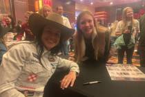Barrel racer Hailey Kinsel poses for a picture with young fan Emma Cox of Jonesboro, Ark., duri ...