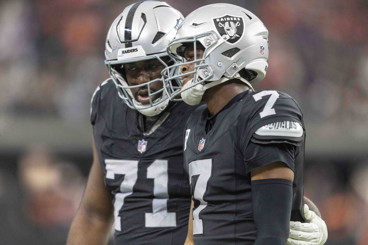 Raiders offensive tackle DJ Glaze (71) consoles quarterback Geno Smith (7) after a hit injured ...
