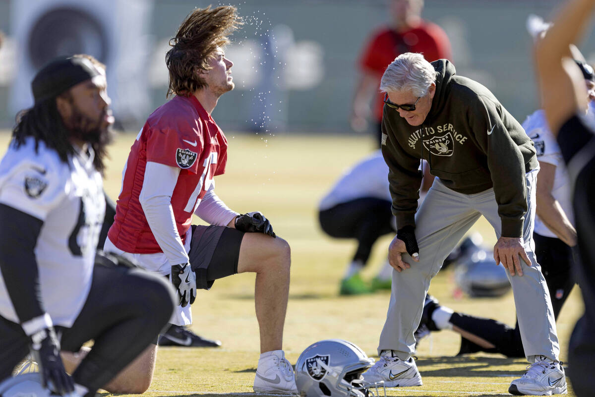 Raiders quarterback Kenny Pickett (15) whips his hair back as head coach Pete Carroll meets wit ...