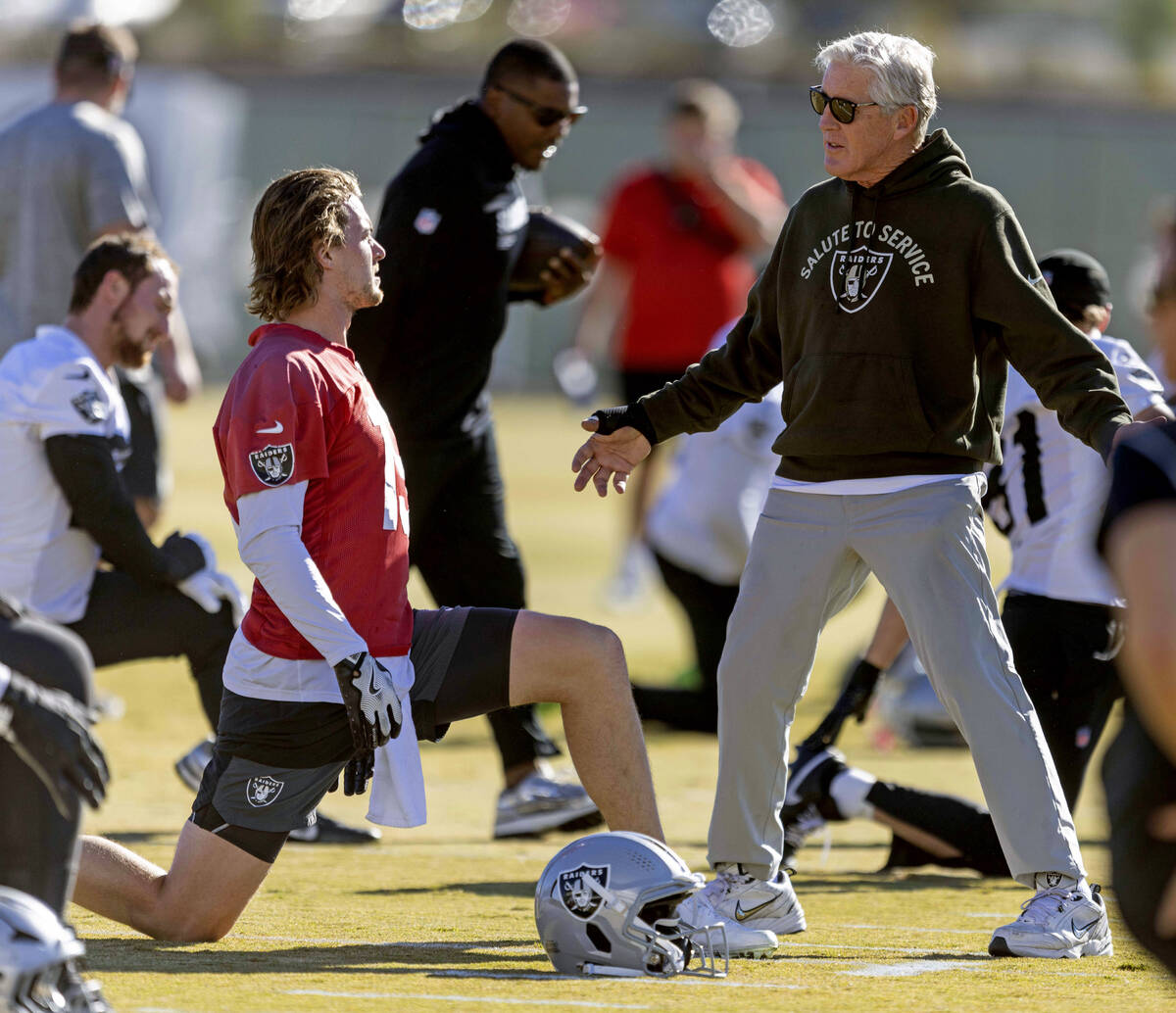 Raiders head coach Pete Carroll interacts with quarterback Kenny Pickett (15) during the team&# ...