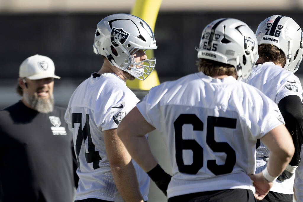 Raiders offensive tackle Kolton Miller (74) meets with offensive lineman Alex Cappa (65) and of ...