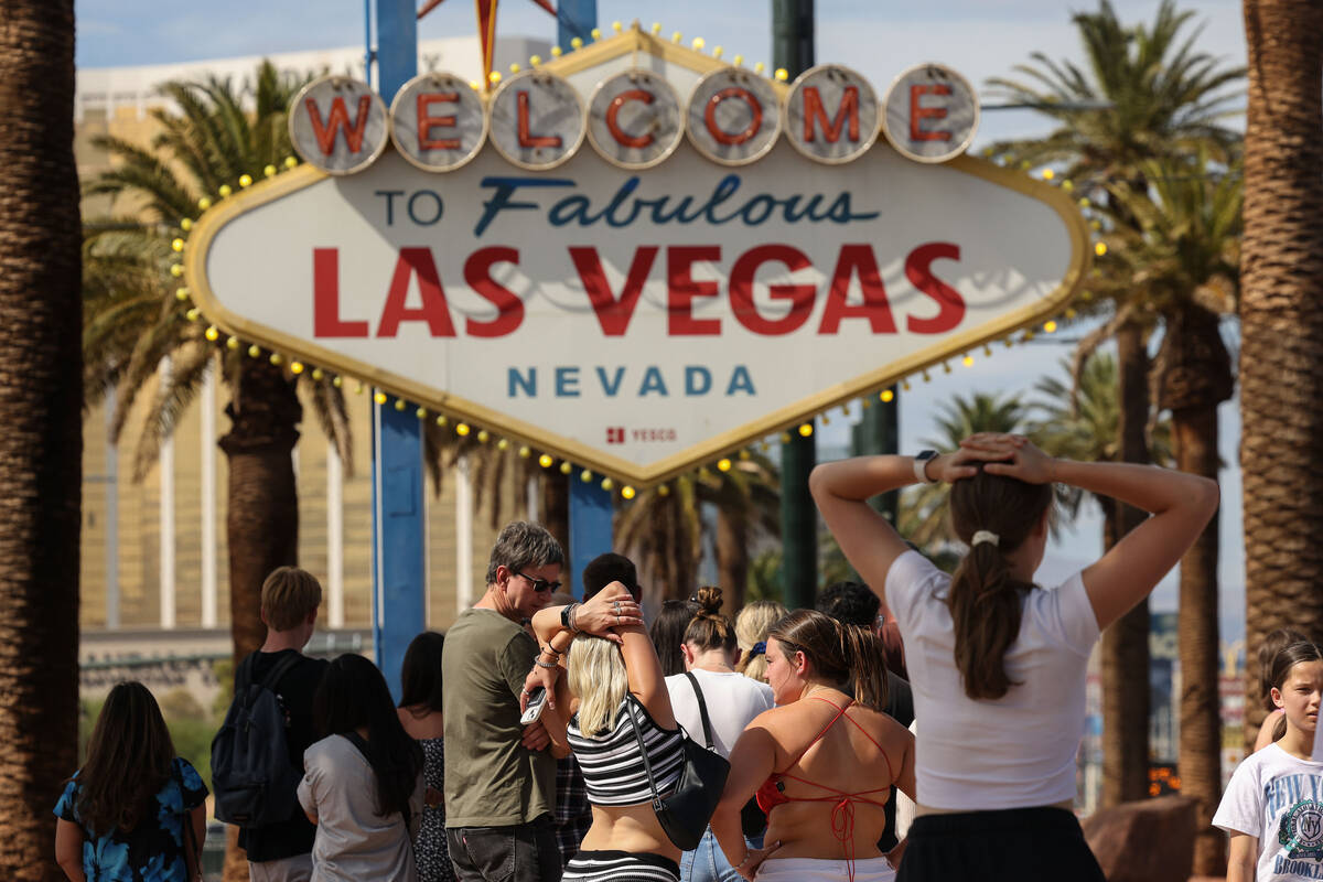 Tourists wait in temperatures topping 100 degrees to take a photo in front of the Welcome to Fa ...