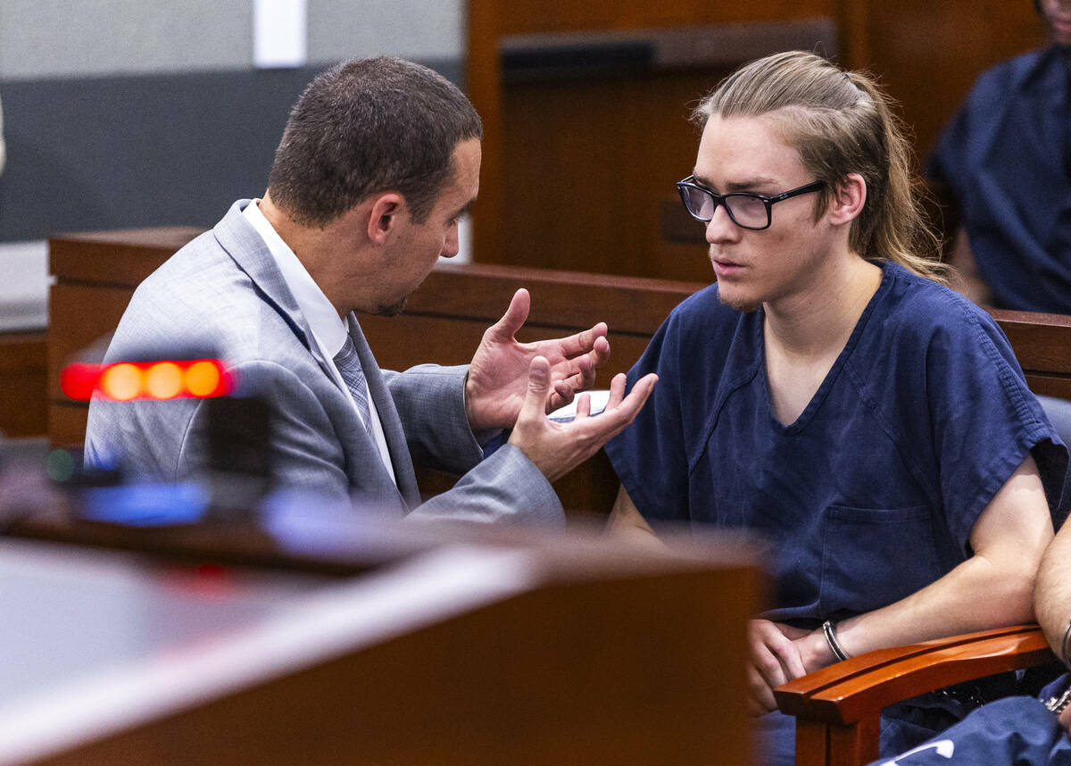 Attorney Ryan Helmick speaks with his client Tyler Johns during an initial arraignment before J ...