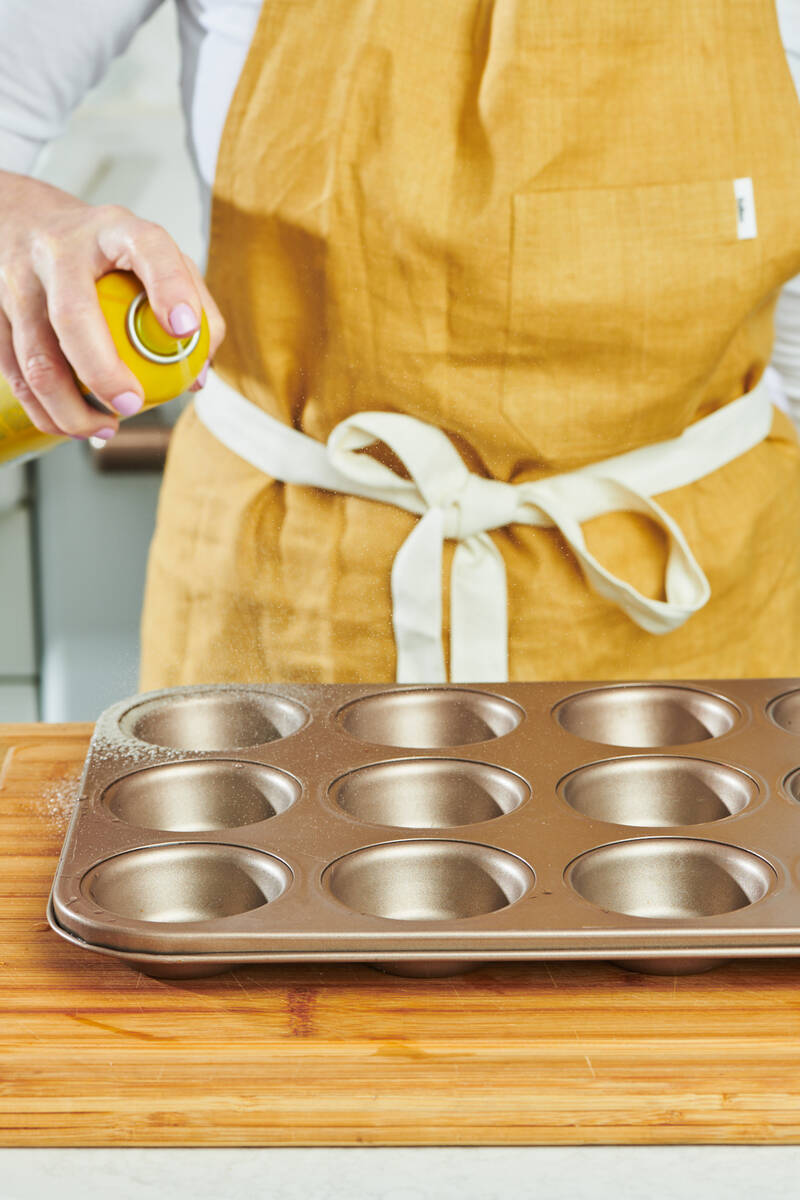 A woman applies non-stick spray to a muffin tin in New York on Oct. 23, 2023. (Cheyenne M. Cohe ...