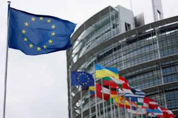 FILE - The European flag, left, flies at the European Parliament in Strasbourg, eastern France. ...
