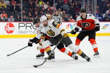 Vegas Golden Knights' Mark Stone, center skates the puck past Philadelphia Flyers' Emil Andrae ...