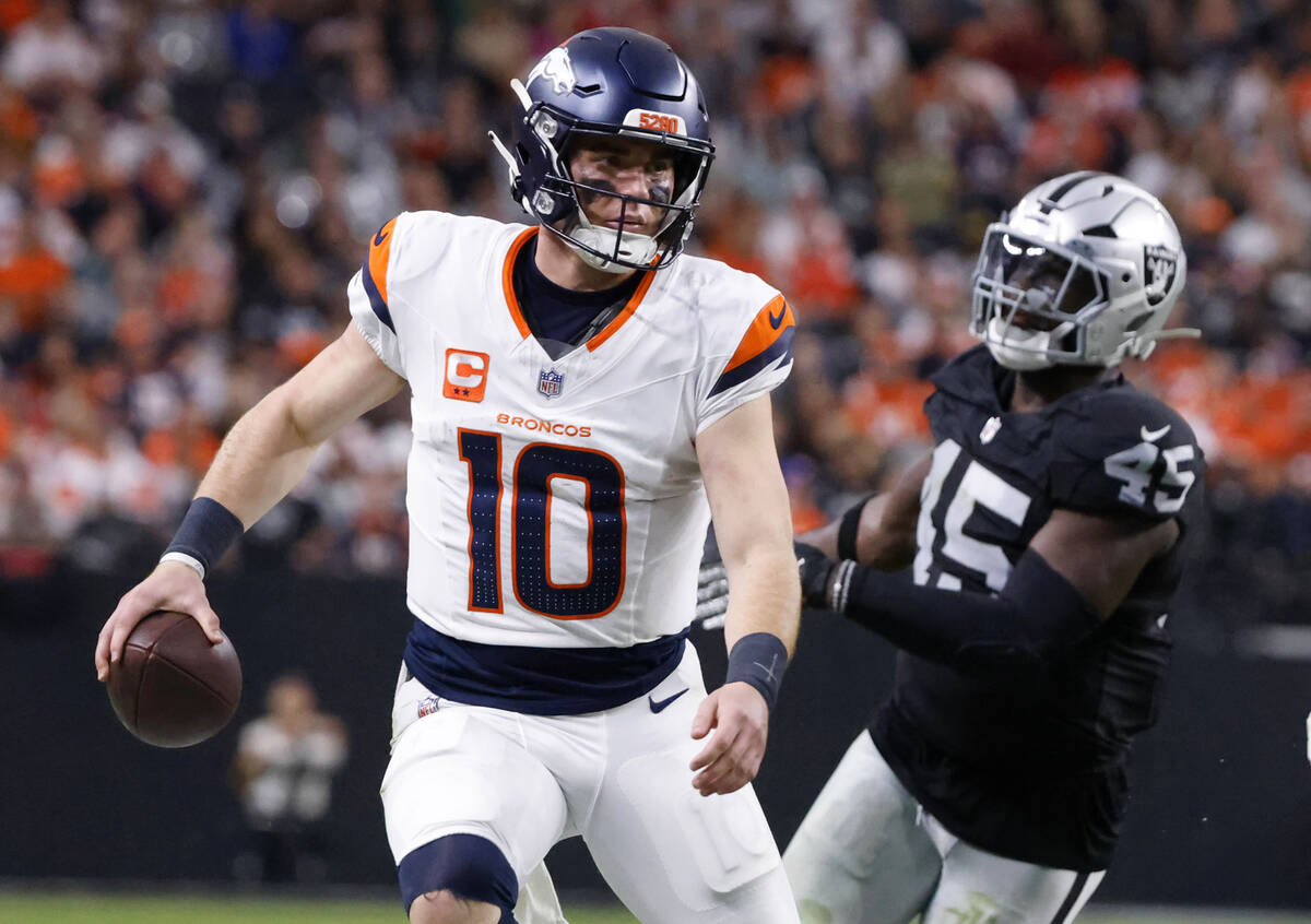 Denver Broncos quarterback Bo Nix (10) is chased down by Raiders linebacker Devin White (45) du ...