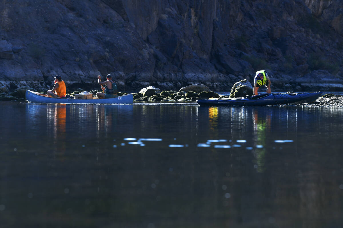 Canoeists and kayakers push off from the shore of the Colorado River below Hoover Dam on Oct. 1 ...