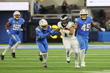 Philadelphia Eagles quarterback Jalen Hurts (1) runs during overtime of an NFL football game ag ...