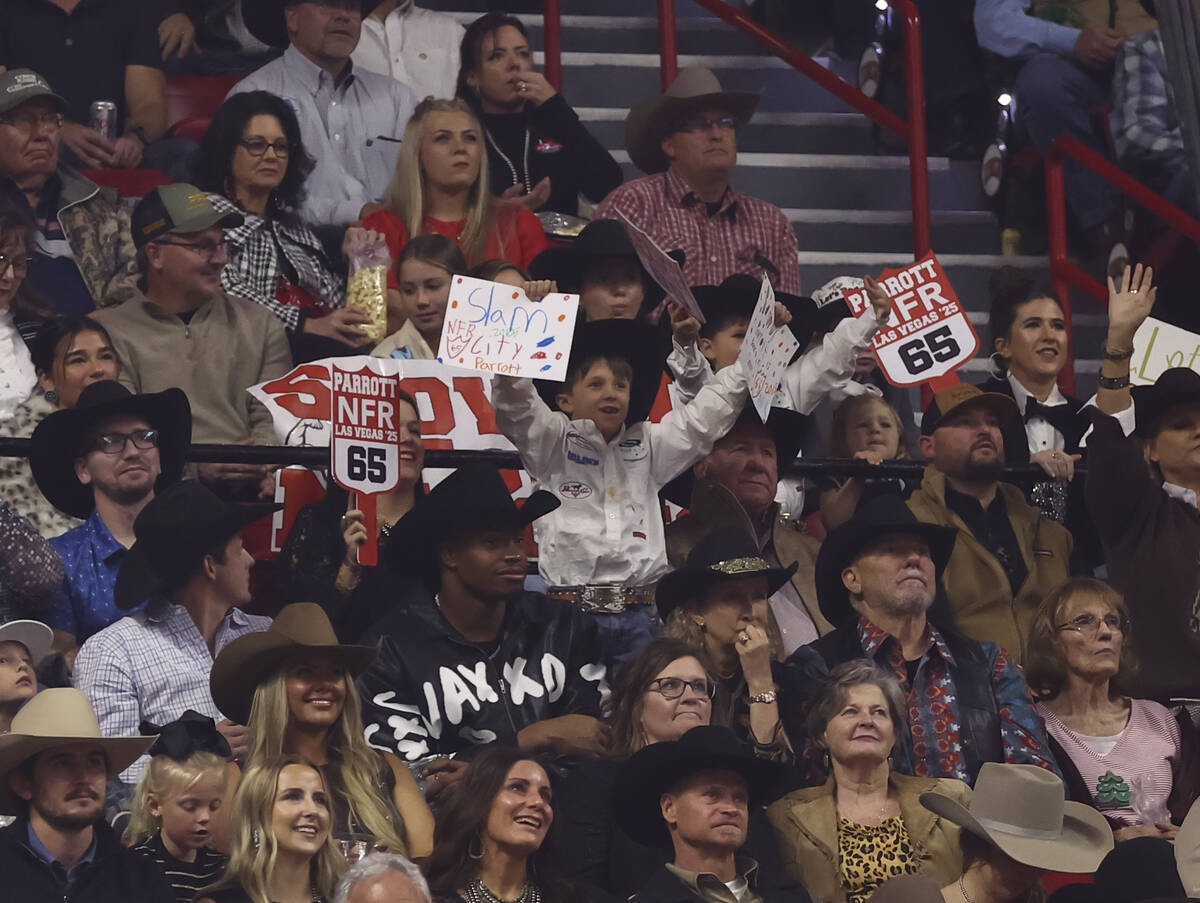 Supporters of steer wrestling competitor Rowdy Parrott cheer during the eighth go-round of the ...
