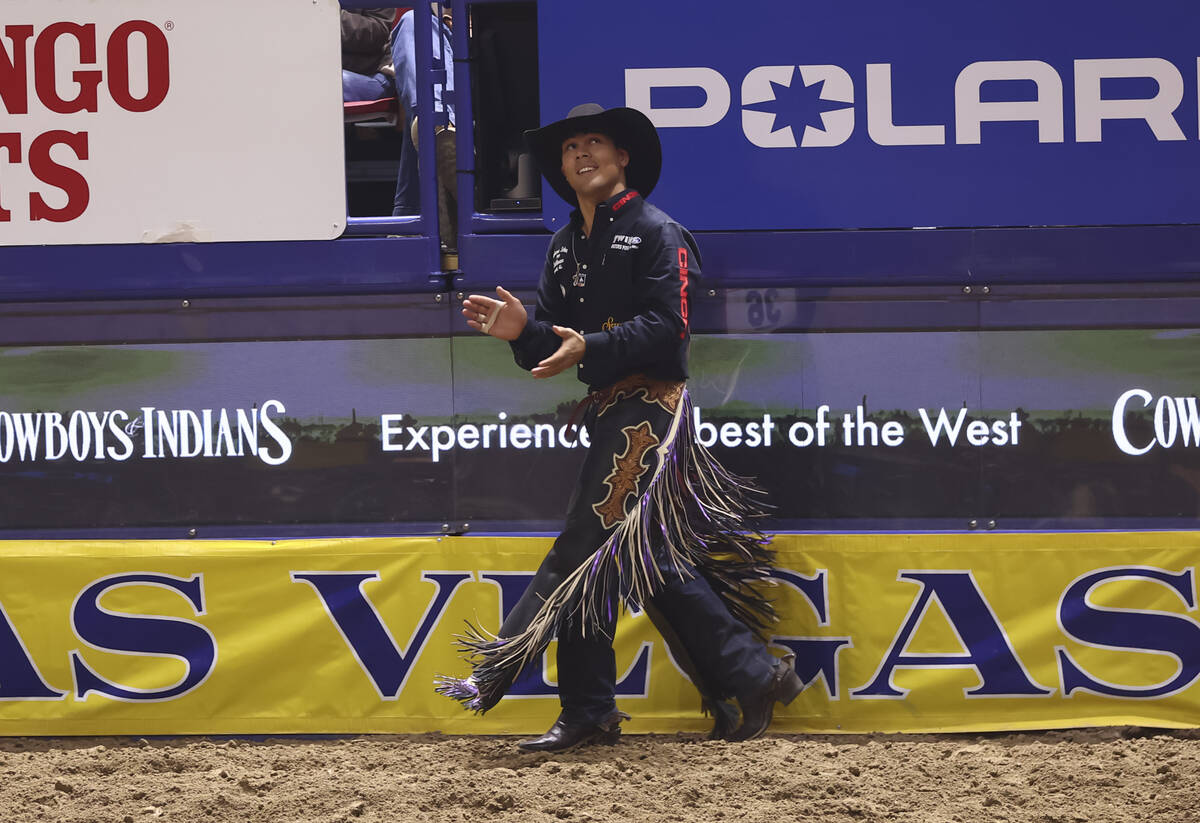 Weston Patterson reacts after competing in saddle bronc riding during the eighth go-round of th ...