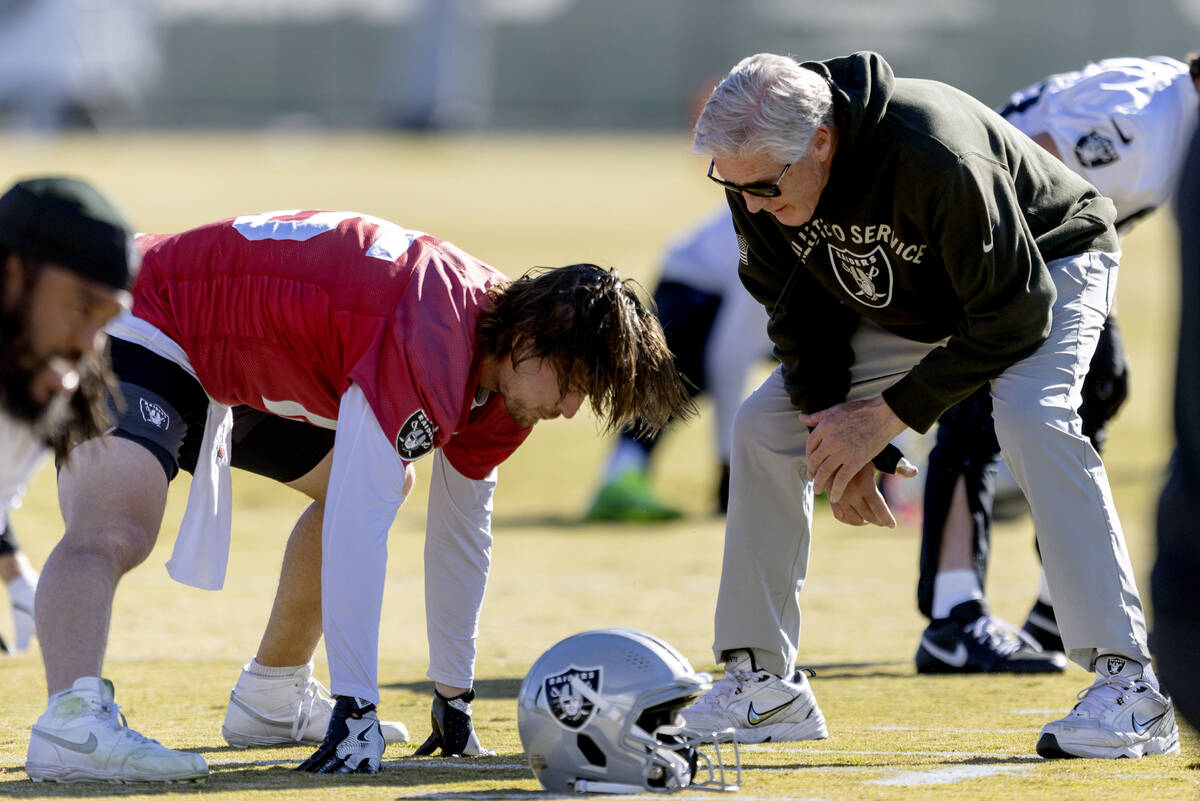 Raiders head coach Pete Carroll speaks with quarterback Kenny Pickett (15) during the team  ...