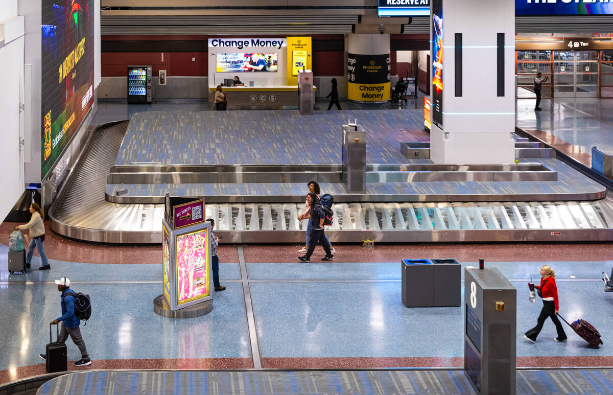 Travelers make their way through the baggage claim at Harry Reid International Airport on Tuesd ...