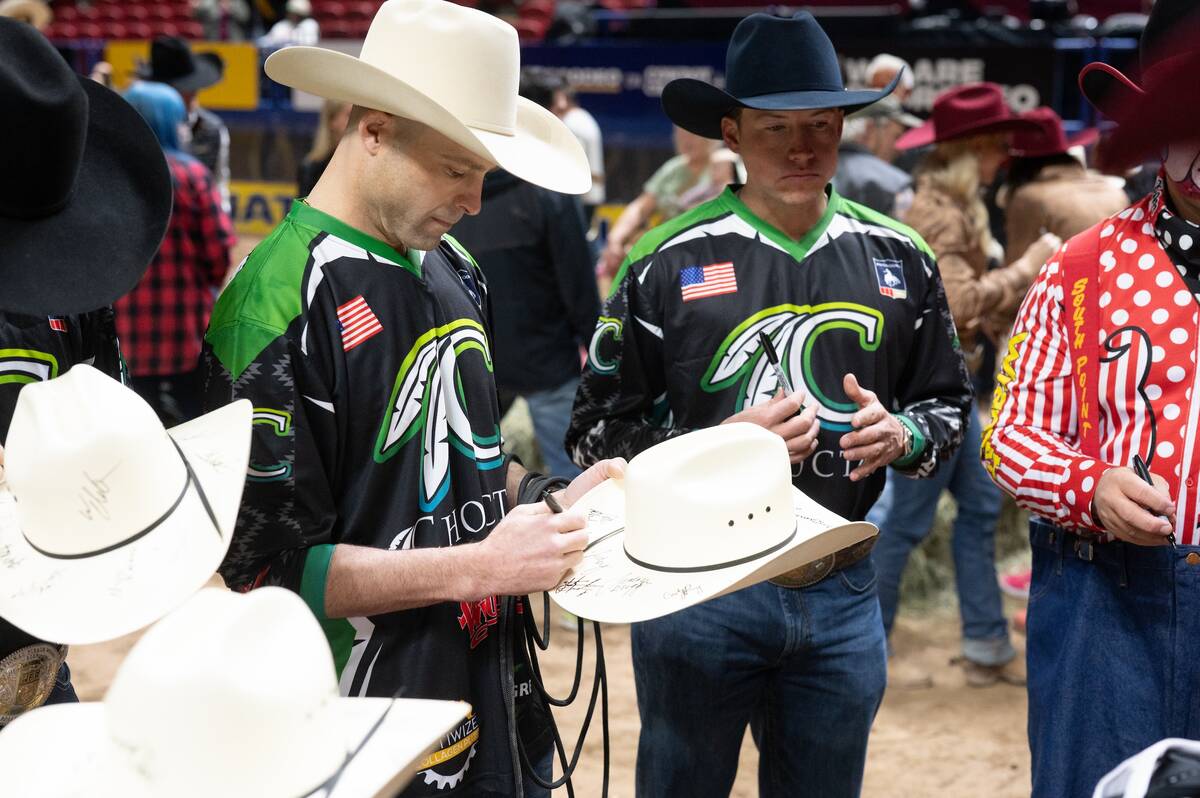 Wrangler NFR bullfighter Dusty Tuckness autographs a cowboy hat for one of the dozens of specia ...