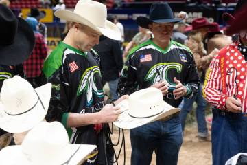 Wrangler NFR bullfighter Dusty Tuckness autographs a cowboy hat for one of the dozens of specia ...