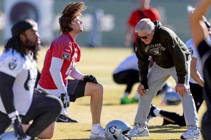 Raiders quarterback Kenny Pickett (15) whips his hair back as head coach Pete Carroll meets wit ...