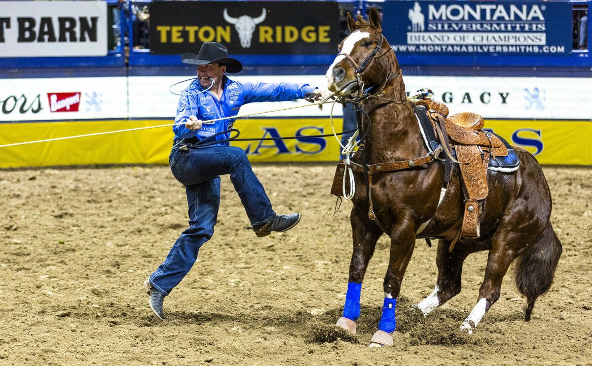 Riley Webb leaves his horse to his calf for the fastest time in Tie-Down Roping during the 9th ...